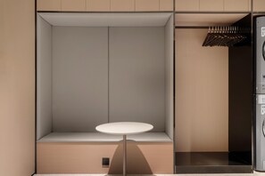 A compact room with a built-in bench, a small round table, and a washing machine. - JI Hotel Xian Bell Tower North Street Metro Stati (Xi'an)