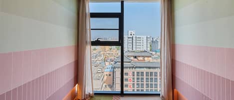 A corridor leading to a sliding glass door with a cityscape view.