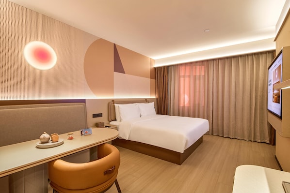 Una habitación de hotel con cama, escritorio, silla y televisión.