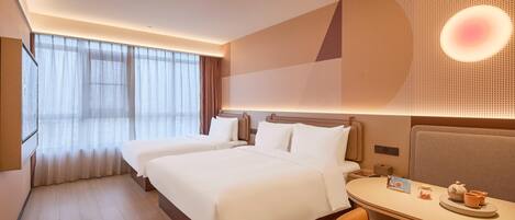 Una habitación de hotel con una cama grande, un escritorio con una silla y una lámpara fijada a la pared.