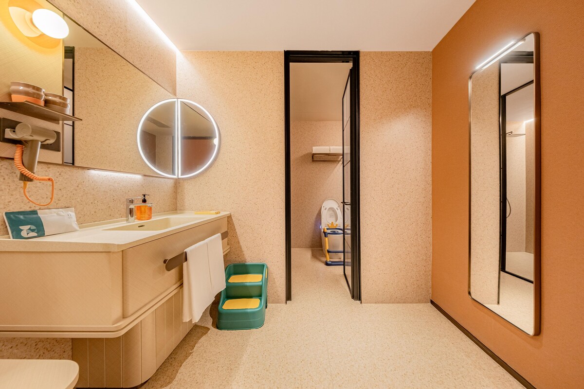 Ein Badezimmer mit Waschtisch, Spiegel, Toilette und Duschbereich.