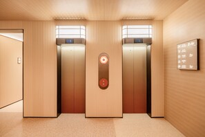 An elevator with a digital display, a control panel, and a wall-mounted information board. - Orange Hotel Xian Xiaozhai Shaanxi History Museum (Xi'an)