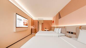 Habitación de hotel con dos camas, un televisor de pantalla plana montado en la pared y una mesita de noche con lámpara.