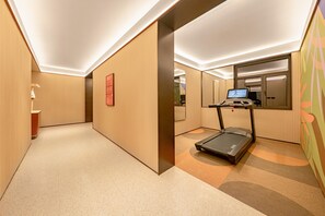 A hotel corridor with a treadmill, a mirror, and a red informational sign. - Orange Hotel Xian Xiaozhai Shaanxi History Museum (Xi'an)