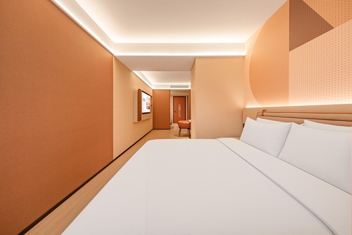 Ein Hotelzimmer mit einem großen Bett, einem Schreibtisch und einem Stuhl.