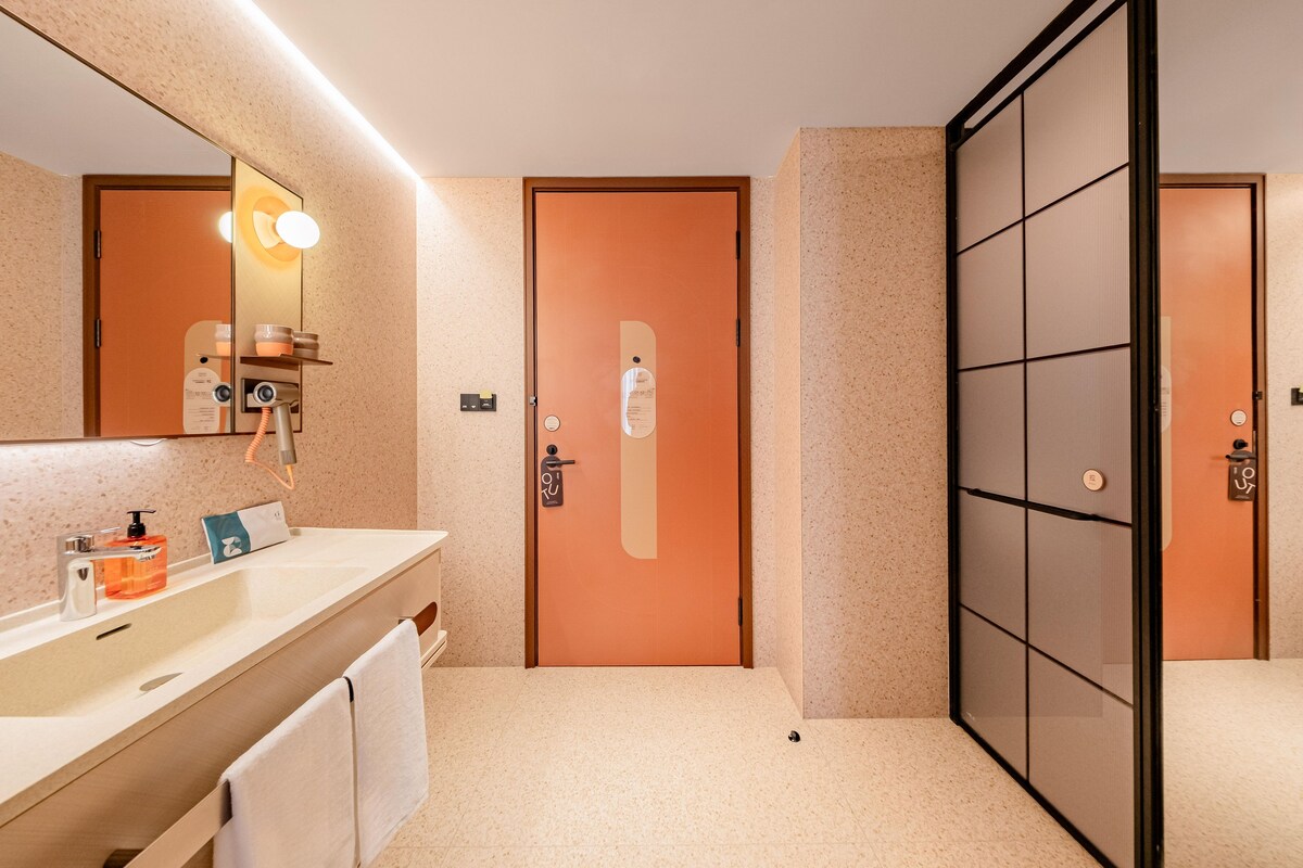 Ein modernes Badezimmer mit großem Spiegel, Waschbecken und Toilette.