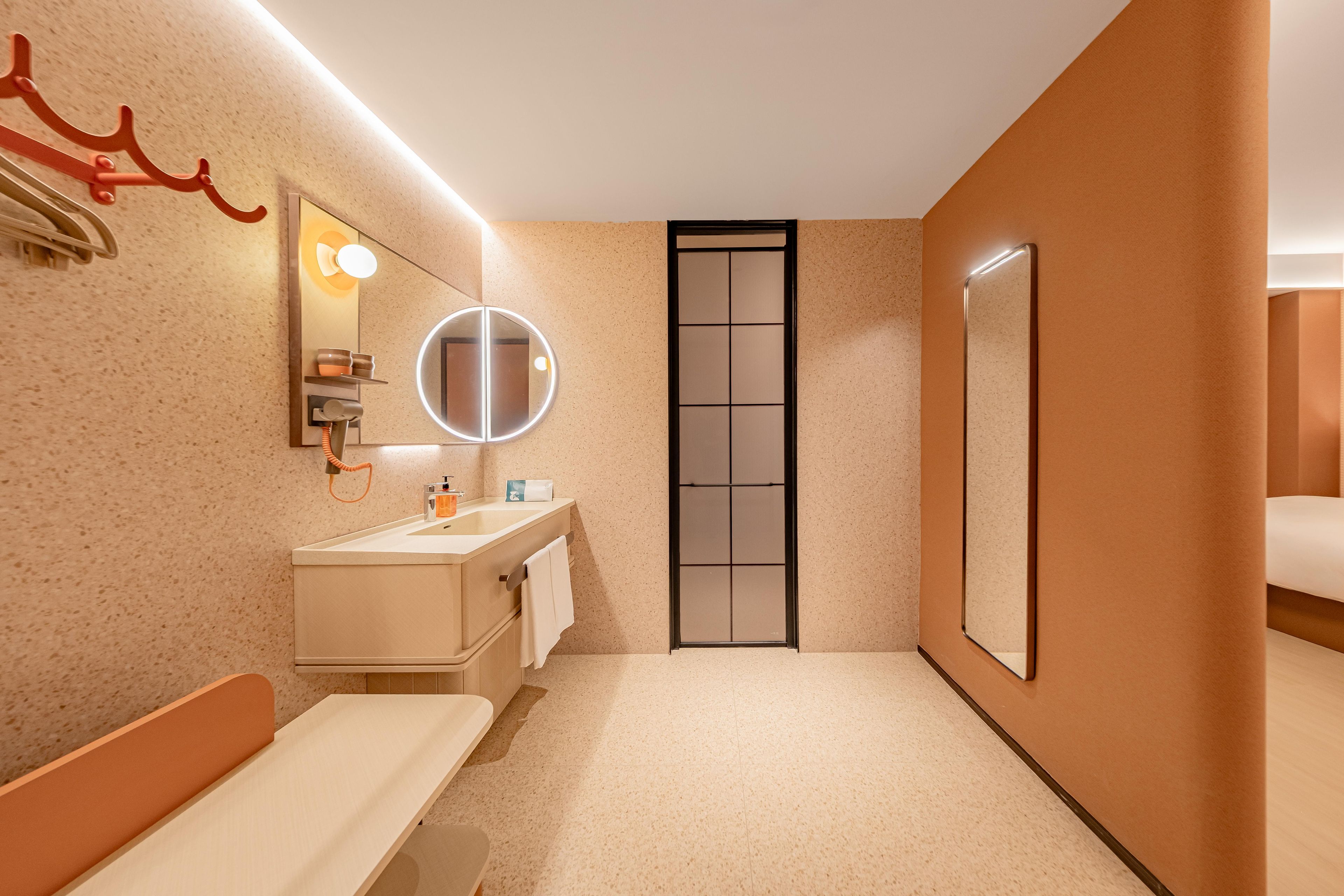 A modern bathroom with a sink, mirror, towel rack, and a toilet.