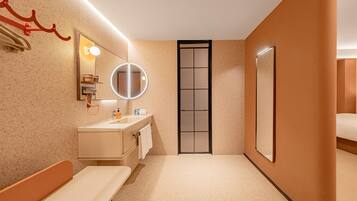 Un baño moderno con lavamanos, espejo, toallero y retrete.
