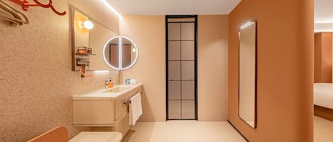 Un baño moderno con lavamanos, espejo, toallero y retrete.
