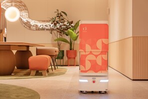 Ein modernes Zimmer mit Heizlüfter, Esstisch, Stühlen und einer Topfpflanze.