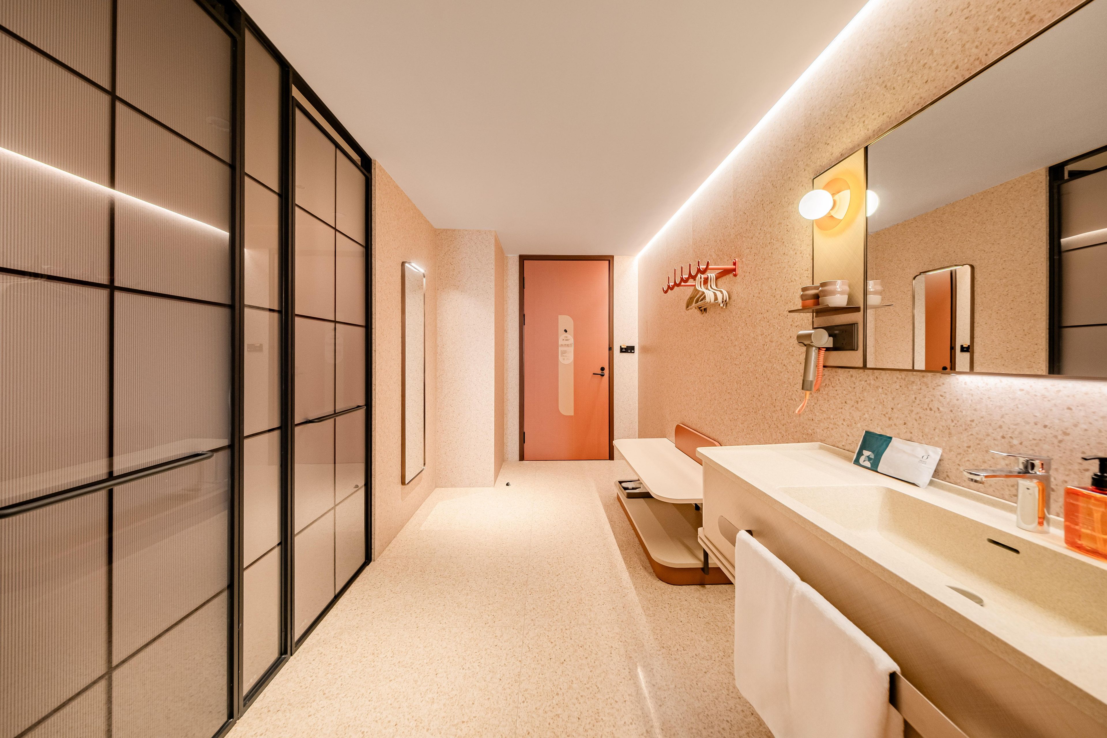 A modern bathroom with a large mirror, a sink, and a towel rack.