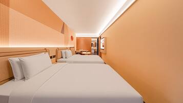 Ein Hotelzimmer mit zwei Betten, einem kleinen Tisch und einem Spiegel.