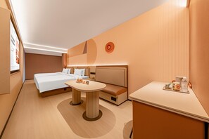 Ein Hotelzimmer mit Bett, einer Couch, einem kleinen Tisch und einer Wandleuchte.