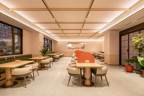 Een modern interieur met een zithoek, tafels en een decoratieve wand.