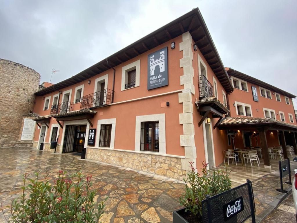 Un bâtiment sur lequel on peut voir une enseigne indiquant « Villa de Brihuega » et une enseigne Coca-Cola.