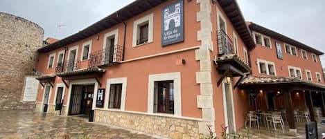 A building with a sign for 'Villa de Brihuega' and a Coca-Cola sign.