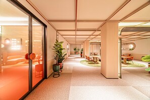 Um interior moderno com um corredor central, áreas de estar e um espaço para refeições.