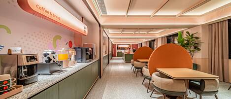 A modern cafe with a long counter, seating area, and a visible coffee machine.