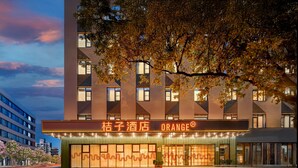 A hotel with a modern facade, large windows, and a prominent sign.