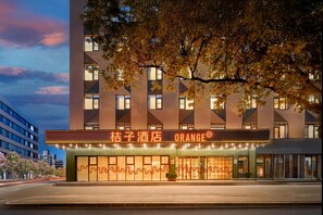 A hotel with a modern facade, large windows, and a prominent sign.