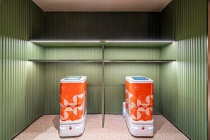 Two orange self-service kiosks in a room with green walls and a speckled floor. - Orange Hotel (Xi'an)