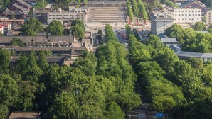 A cityscape with traditional architecture, modern buildings, and a mountainous backdrop. - Orange Hotel (Xi'an)