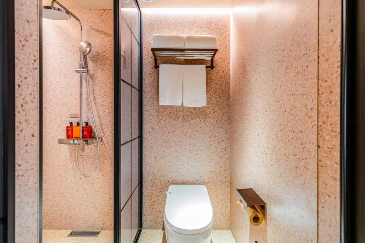 Un baño moderno con cabina de ducha de vidrio, inodoro y barra para toallas.