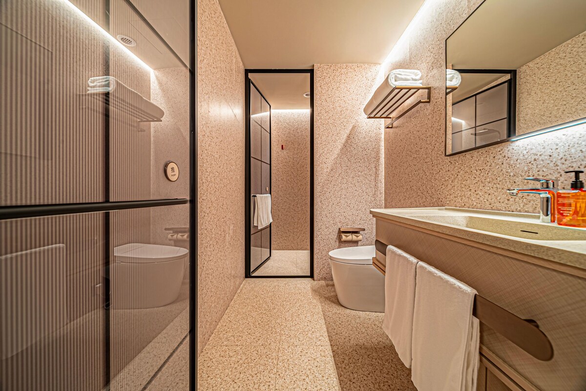 A modern bathroom with a glass shower enclosure, a vanity with a sink, and a toilet.