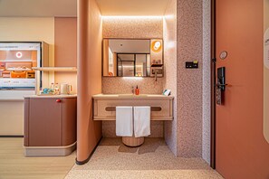 A modern bathroom with a sink, mirror, towel, and a shower area.