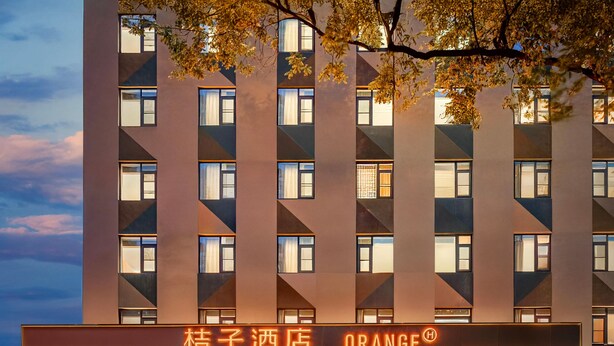 A modern hotel with a flat facade, multiple windows, and a sign that reads 'ORANGE'. - Orange Hotel (Xi'an)