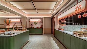 A modern kitchen with a central island, overhead lighting, and a counter displaying kitchen utensils.