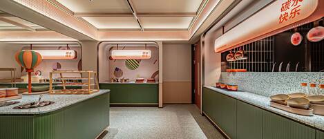 A modern kitchen with a central island, overhead lighting, and a counter displaying kitchen utensils.