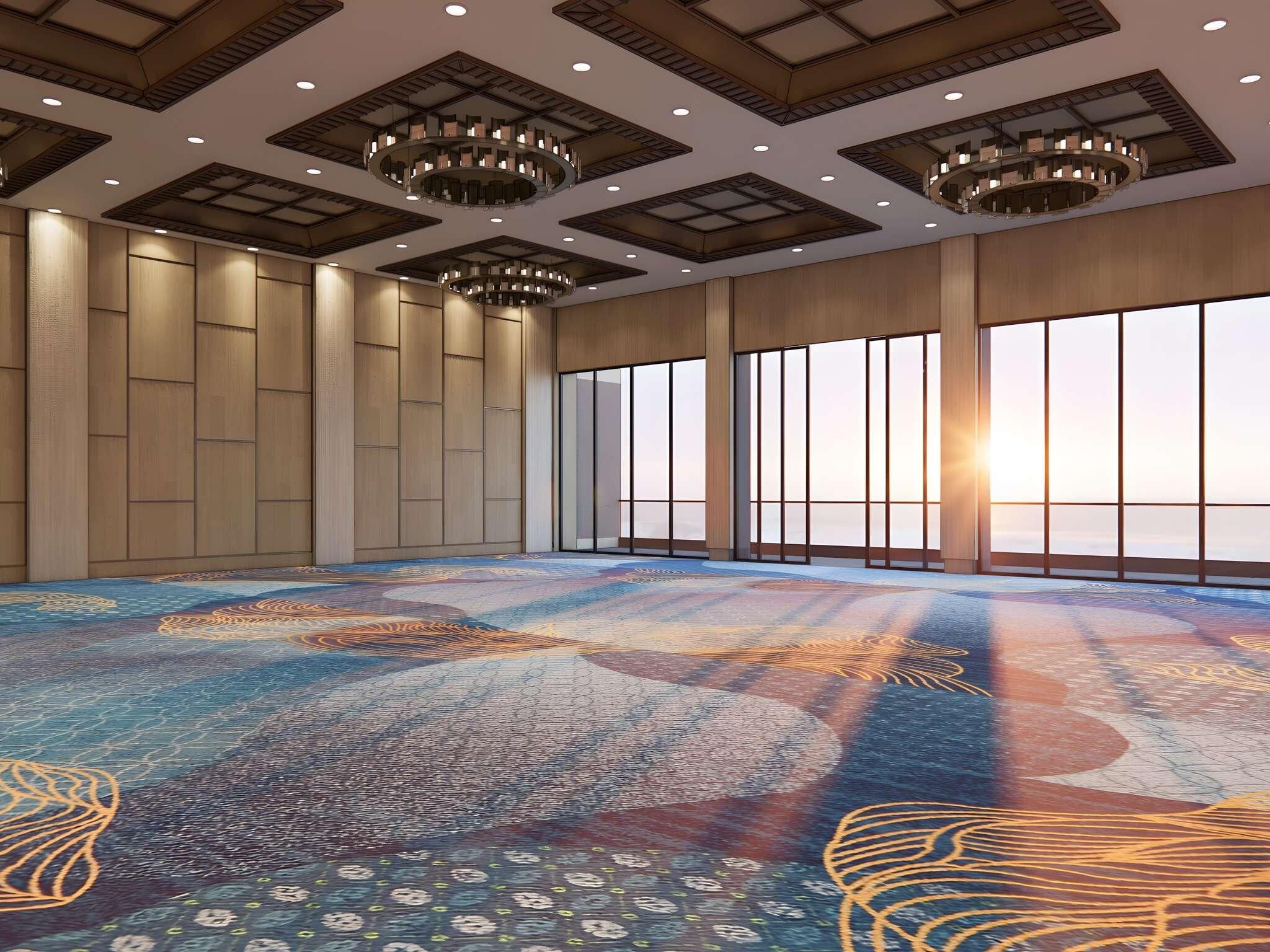 Una habitación amplia con alfombra estampada, ventanas grandes y un techo alto con iluminación empotrada.