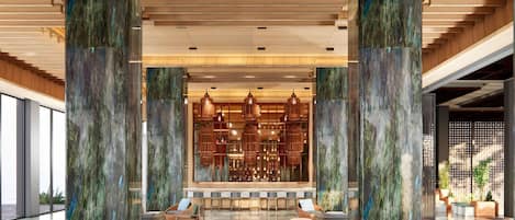 A spacious lobby with high ceilings, a bar area, and seating arrangements.