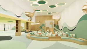 Un intérieur moderne avec un espace salon central, un escalier et des œuvres d’art abstraites sur les murs.