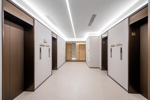 A corridor with two elevators, each marked with a number. - JI Hotel (Xi'an)