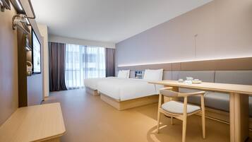 Una habitación de hotel moderna con cama, escritorio, silla y sofá.
