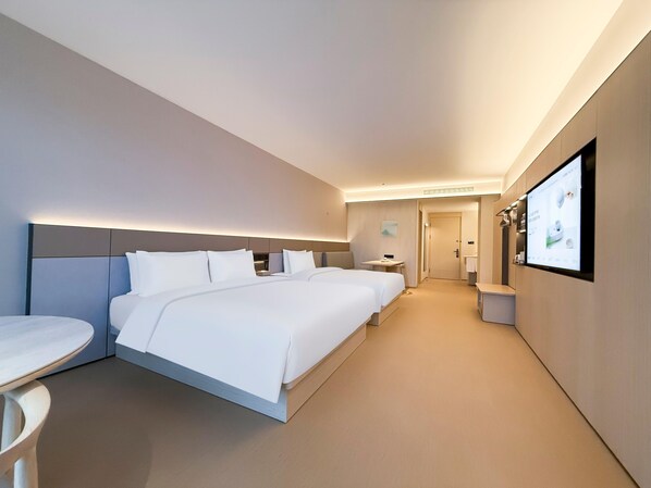 A hotel room with a large bed, a bedside table, a TV mounted on the wall, and a bathroom visible through an open door. - JI Hotel (Xi'an)