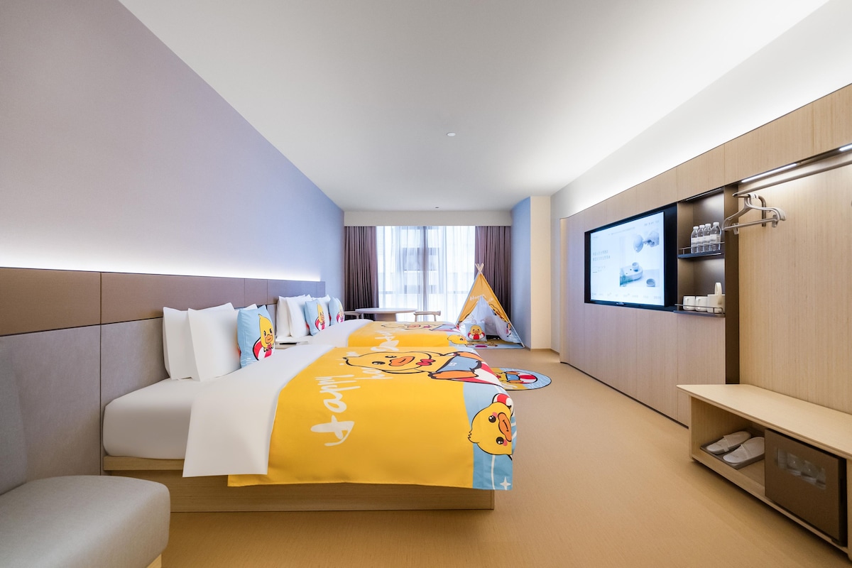 A hotel room with a bed, a TV, a small table, and a window.
