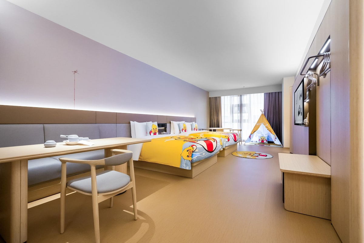 A modern hotel room with a bed, a desk, and a chair.