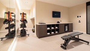 Un gimnasio con equipo de ejercicio, una recepción y un letrero en la pared.