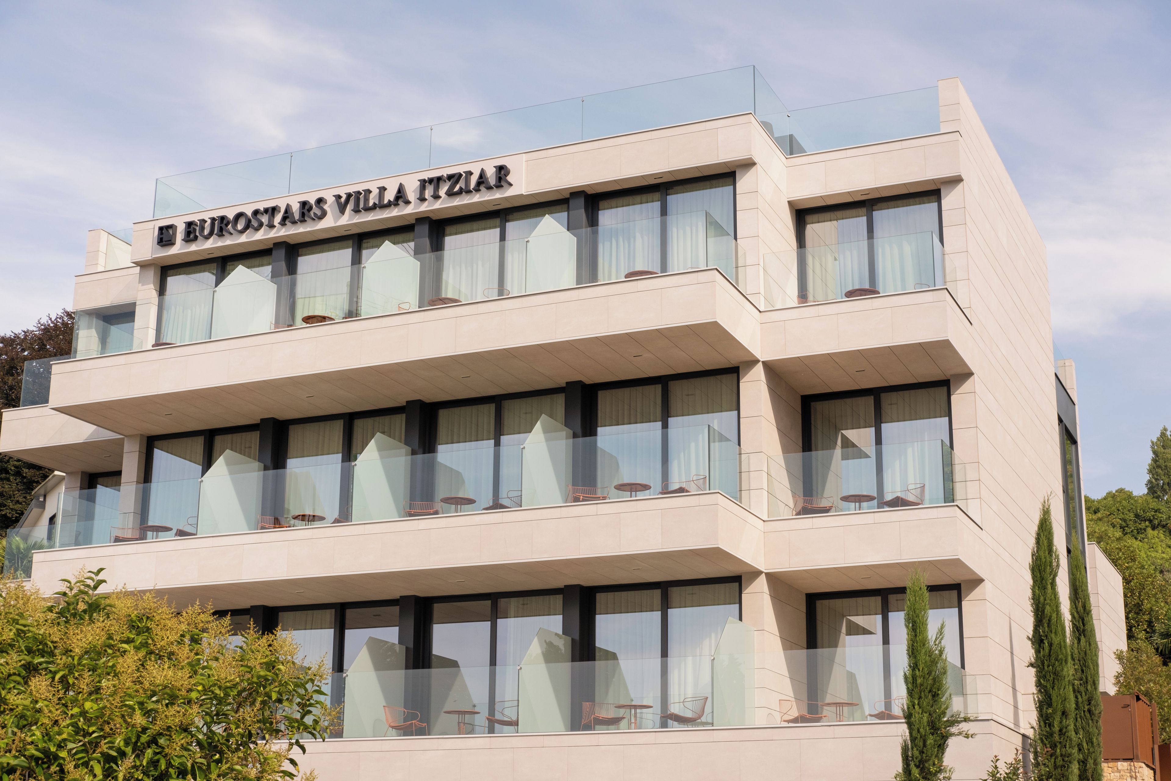 Un edificio de varios pisos con balcones y ventanas grandes.