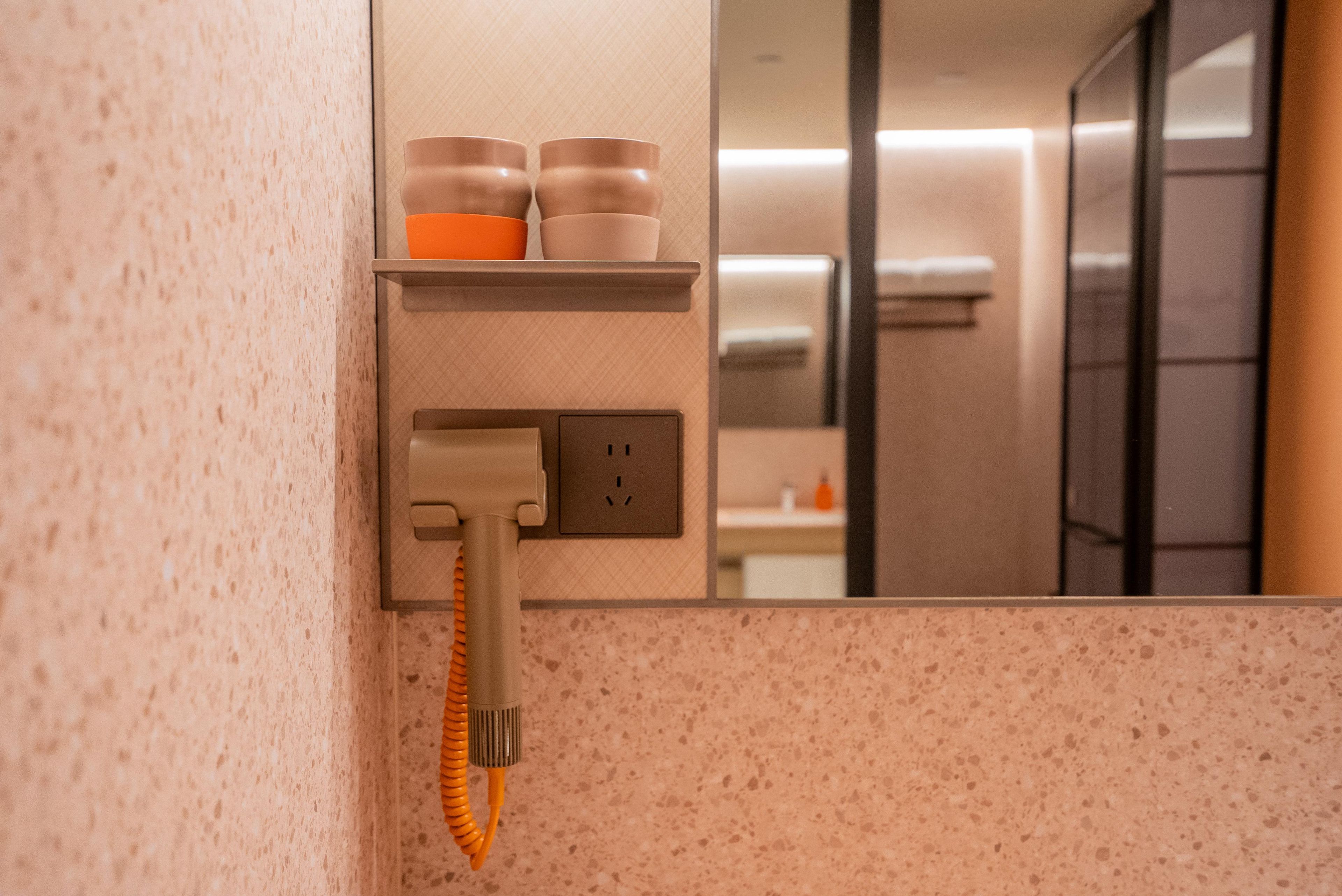 Une salle de bain équipée d’un porte-serviettes, d’un miroir et d’un distributeur de serviettes.