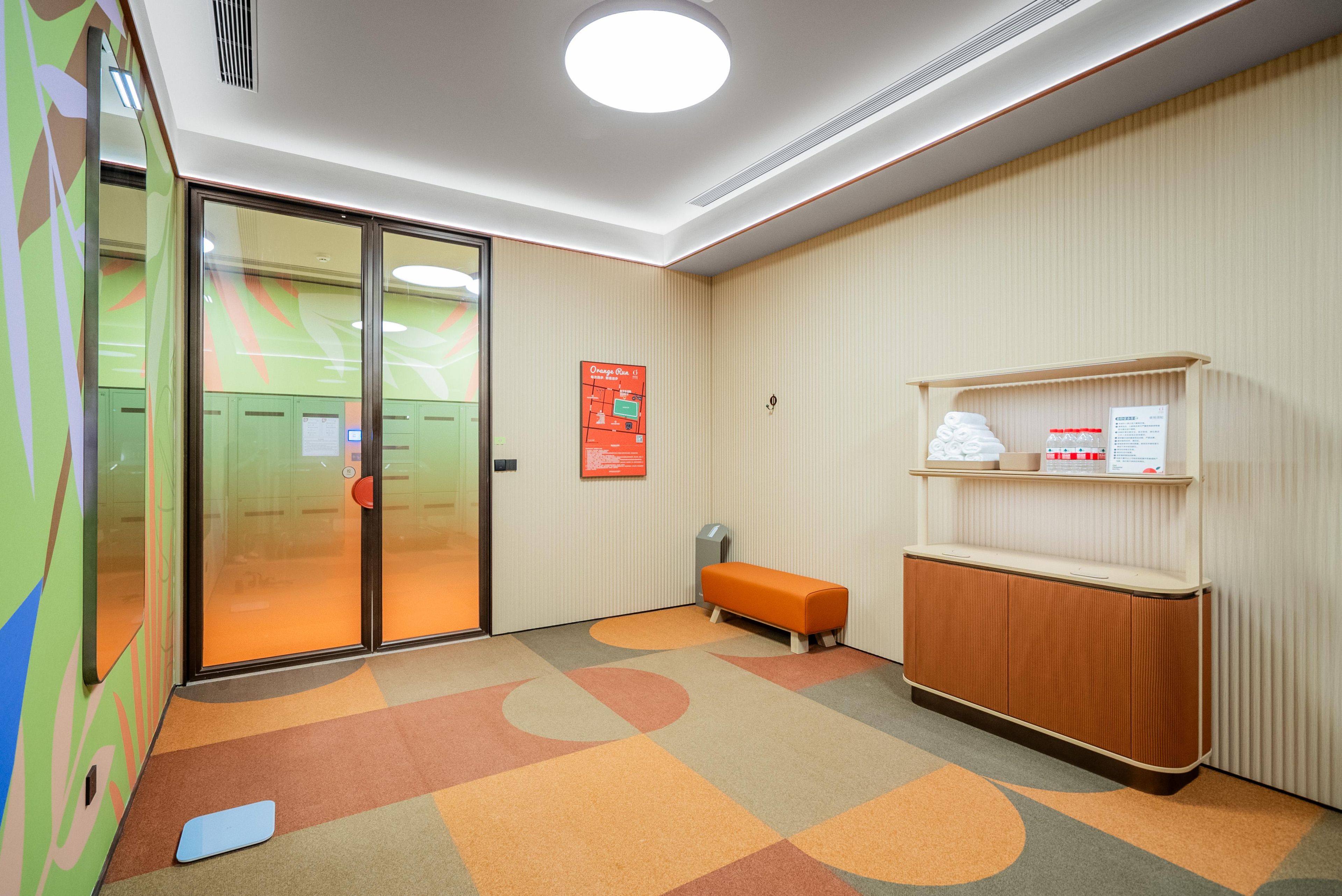 A reception area with a glass door, a bench, a bulletin board, and a wooden counter with a shelf.