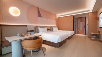 Quarto de hotel moderno com uma cama grande, uma mesa com cadeira e uma mesinha.