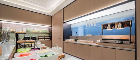 Una cocina moderna con encimera de mármol, electrodomésticos de acero inoxidable y varios cuencos para preparar alimentos.