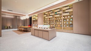 Un interior moderno con una isla central, estanterías y un comedor.