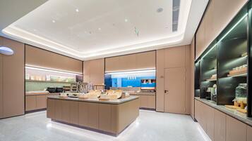 A modern kitchen with a central island, built-in appliances, and a view of the sea.