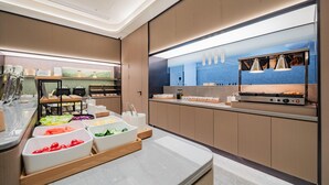 Una cocina moderna con encimera de mármol, electrodomésticos de acero inoxidable y varios cuencos para preparar alimentos.