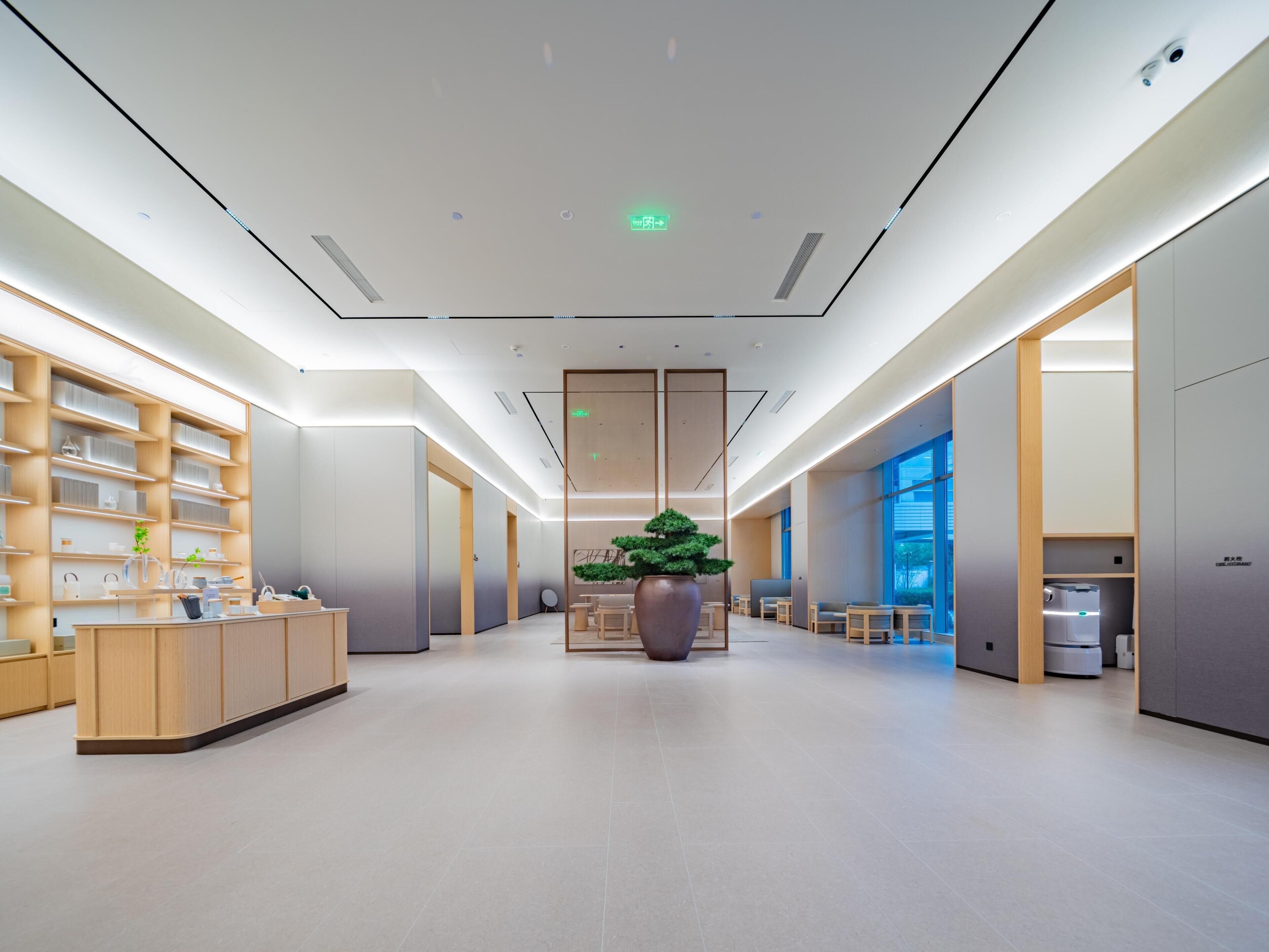 A modern interior with a reception desk, shelving units, and seating area.